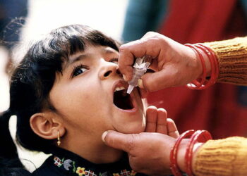 A young Indian girl receiving a dose of oral polio vaccine by a trained healthcare worker. Original image sourced from US Government department: Public Health Image Library, Centers for Disease Control and Prevention. Under US law this image is copyright free, please credit the government department whenever you can”.